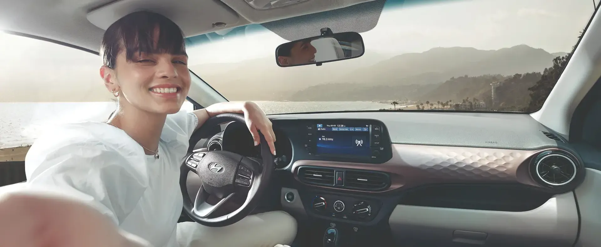 Imagen de mujer al volante de un Grand i10 Sedan