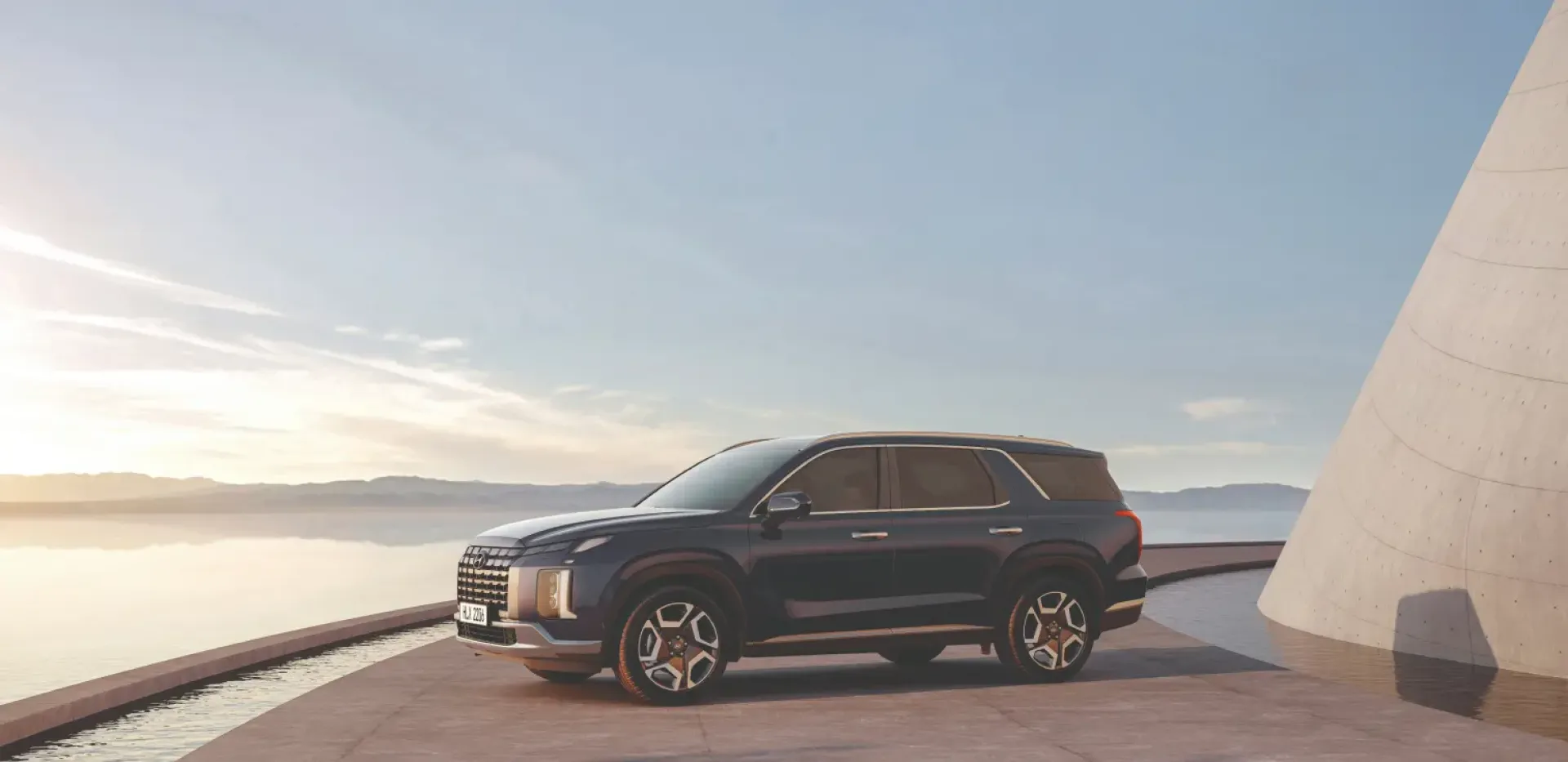Imagen del SUV Palisade estacionado en la costa al atardecer.