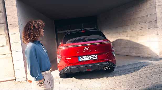 Imagen de mujer observando las luces traseras del KONA rojo