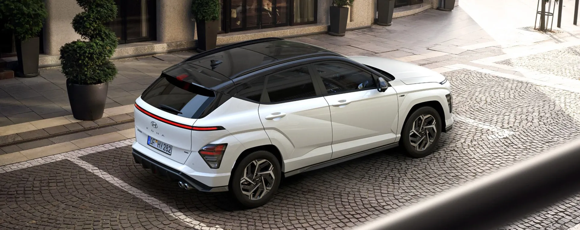 Imagen isometrica de KONA eléctrico blanco en calle empedrada